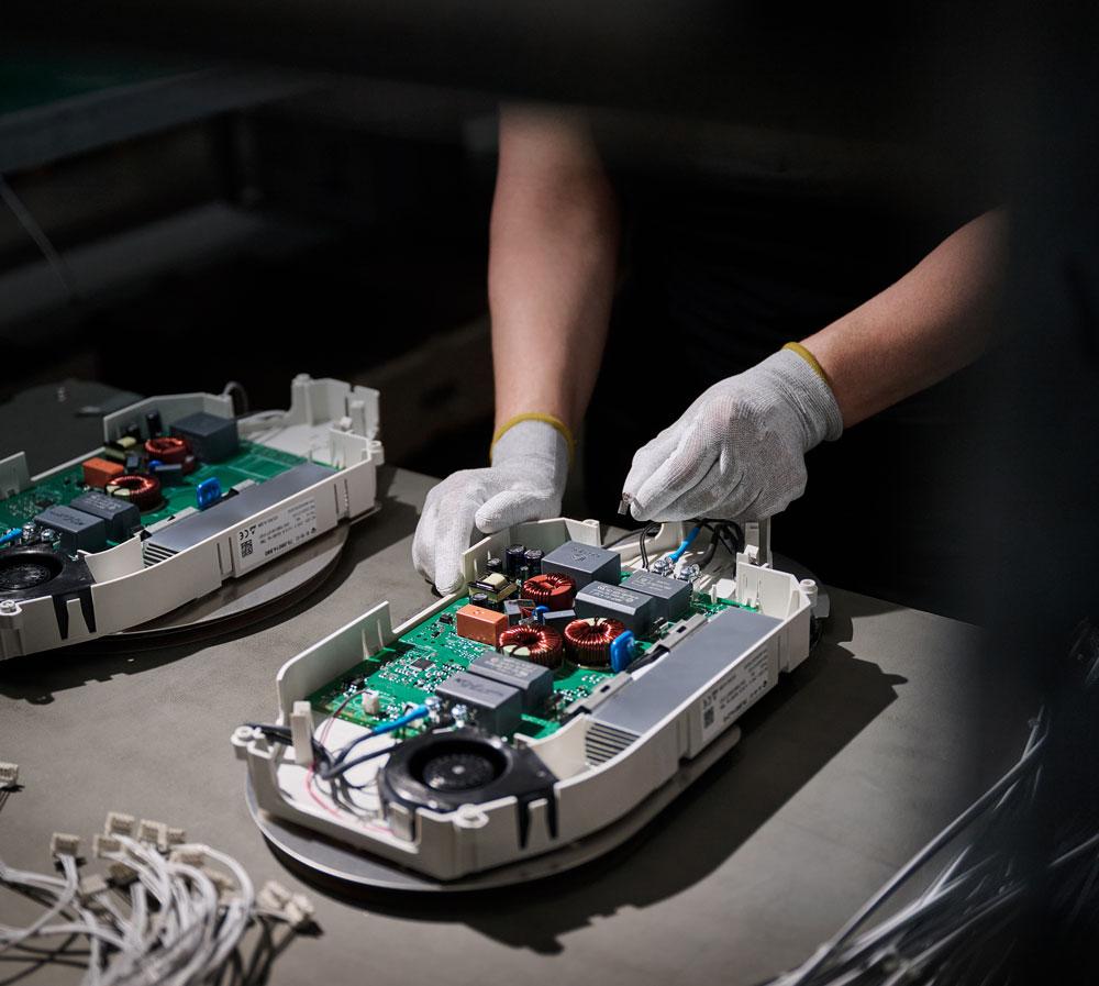 Eine Person arbeitet mit Handschuhen an einem Kochfeld.