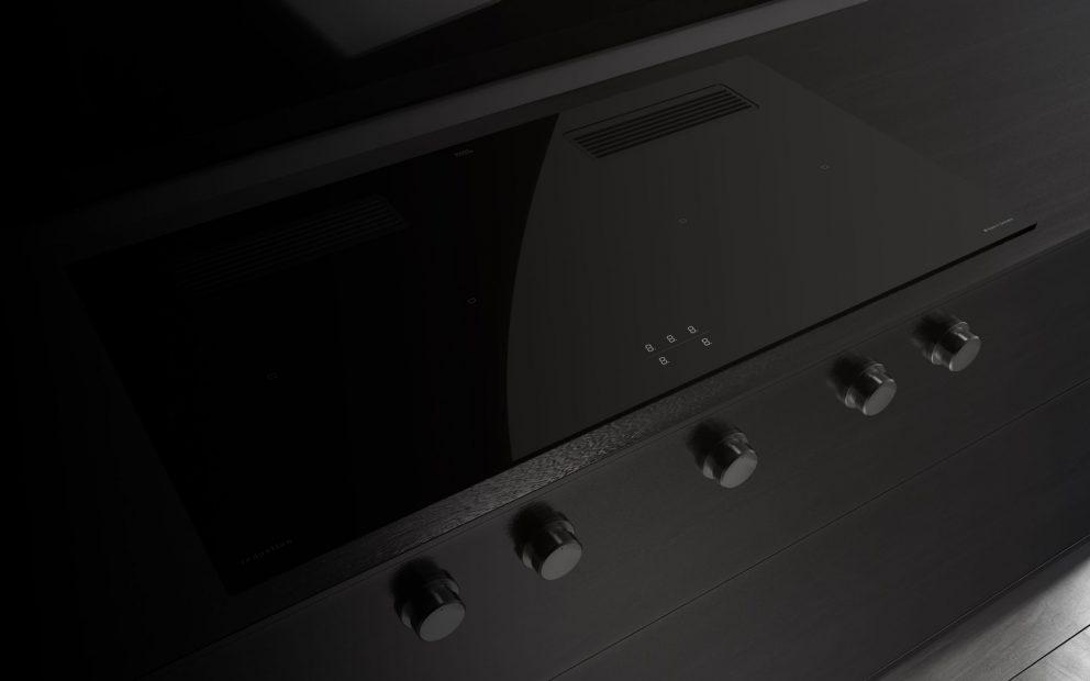 Zu sehen ist ein Herd mit schwarzer glatter Oberfläche und Knebeln.